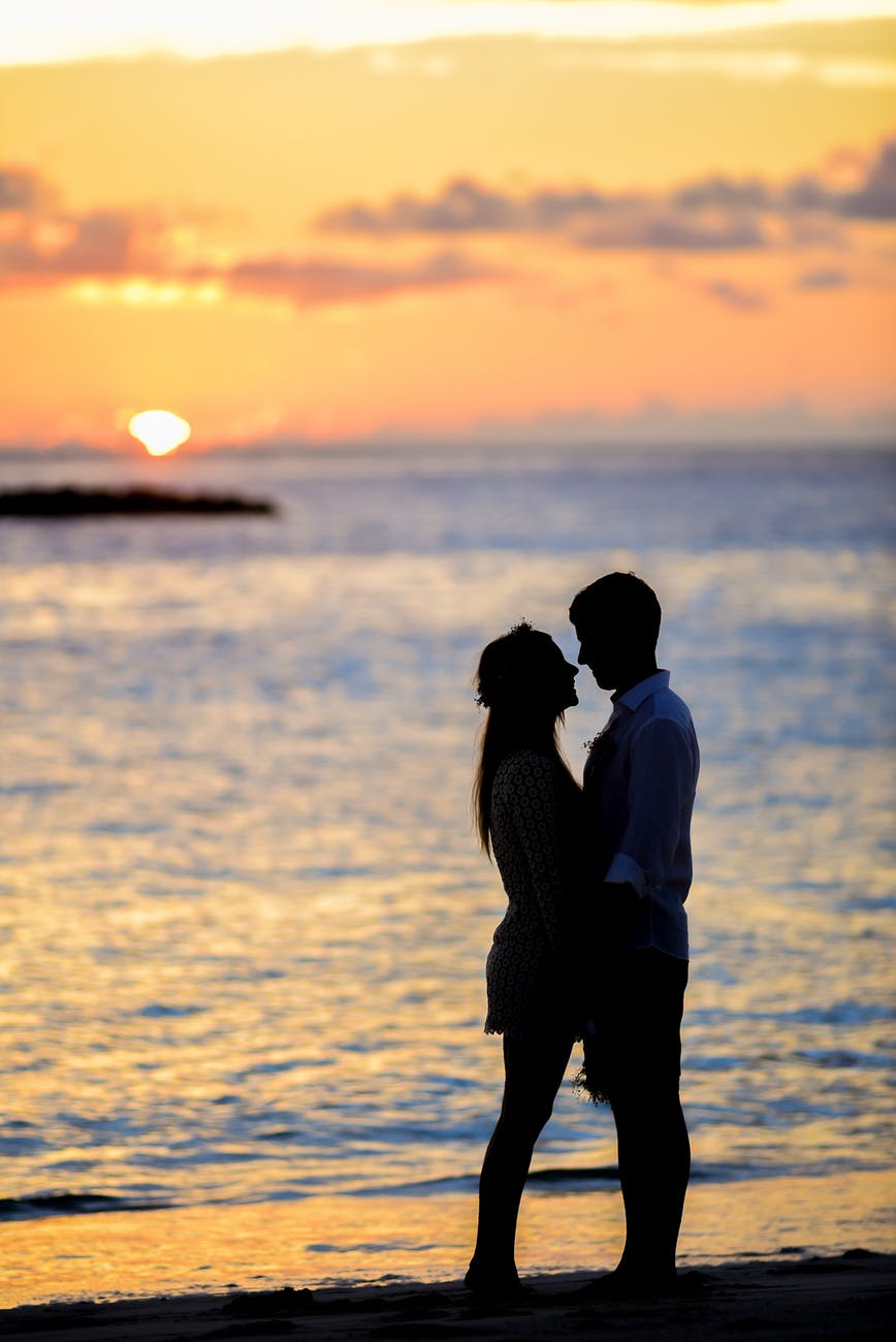 silhouette of couple on seashore