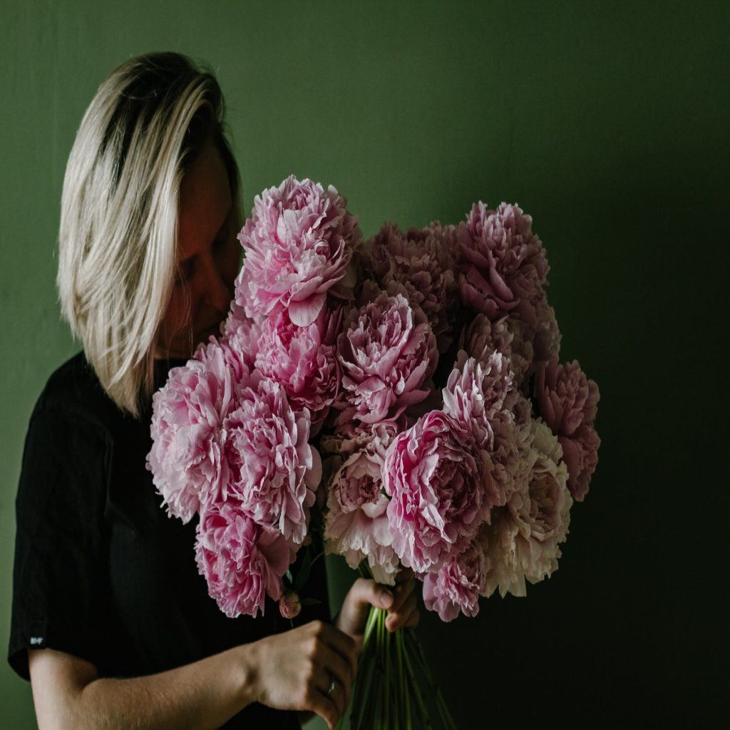 woman smelling bunch of lush flowers