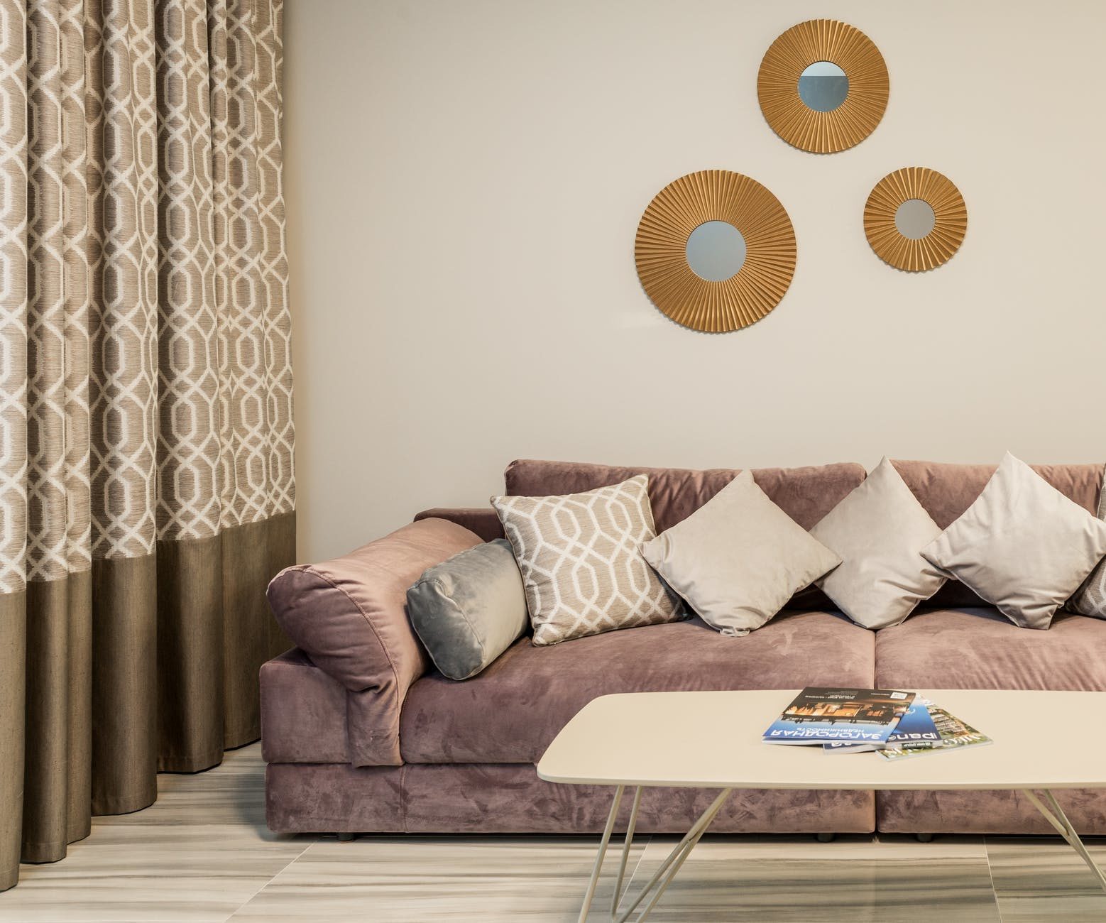 soft couch with pillows at wall decorated with mirrors