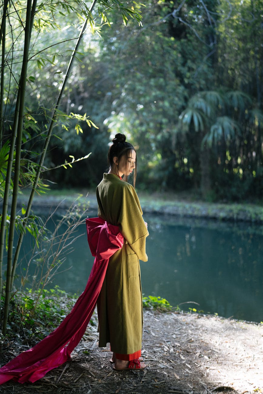 woman in green kimono standing near a river